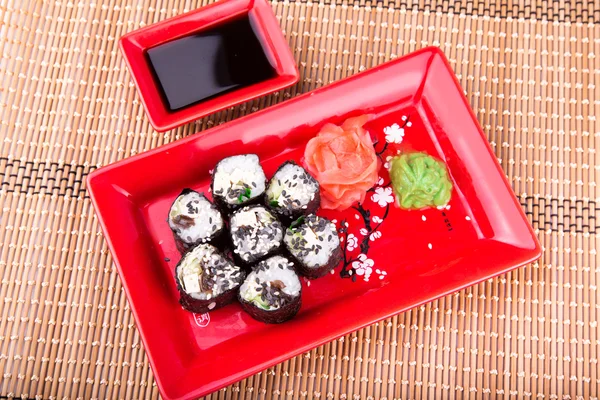 Rollo de sushi vegetariano servido en un plato rojo — Foto de Stock