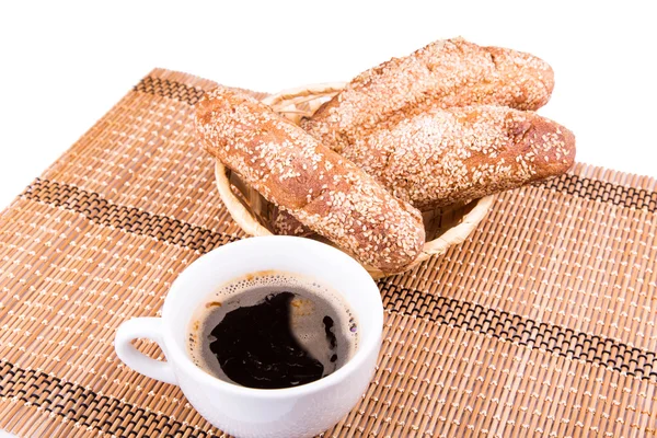 Rollos de pan recién horneados con sésamo con taza de café —  Fotos de Stock
