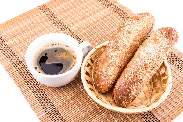 Rouleaux de pain frais au four avec sésame et tasse de café — Photo