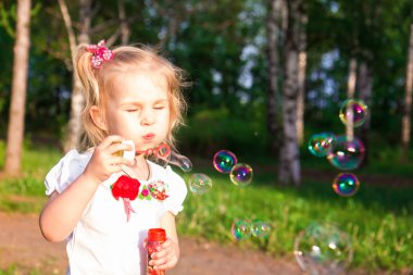 güzel küçük bir kız sabun köpüğü üfleme