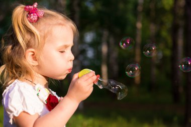 güzel küçük bir kız sabun köpüğü üfleme