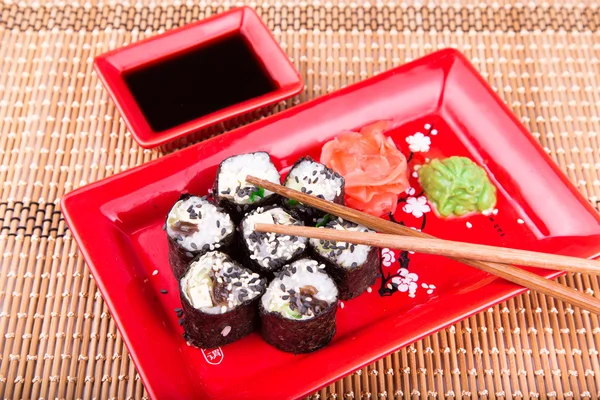 Vegetarian sushi roll served on a red plate — Stock Photo, Image