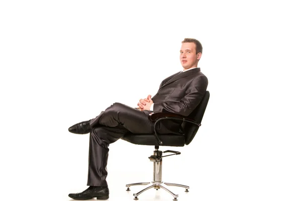 Confident smiling young businessman sitting on a chair — Stock Photo, Image