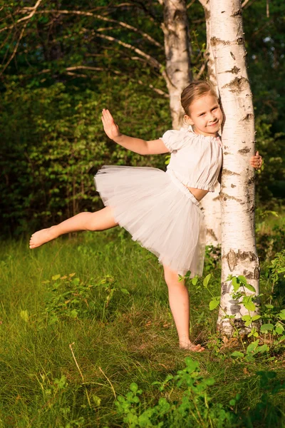 Hermosa niña en el bosque cerca de abedul — Foto de Stock