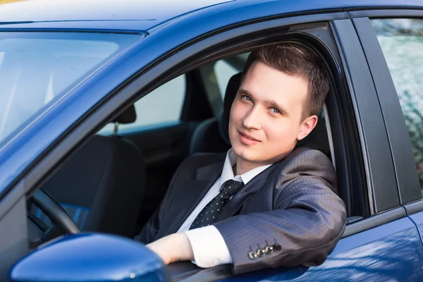Красивый молодой бизнесмен в своей новой машине — стоковое фото