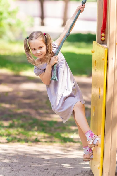 Девочка на открытой детской площадке — стоковое фото
