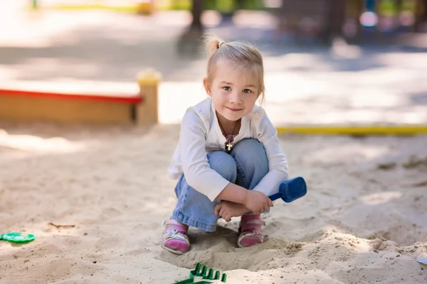 幸せな小さな女の子が、sendbox で遊んで — ストック写真