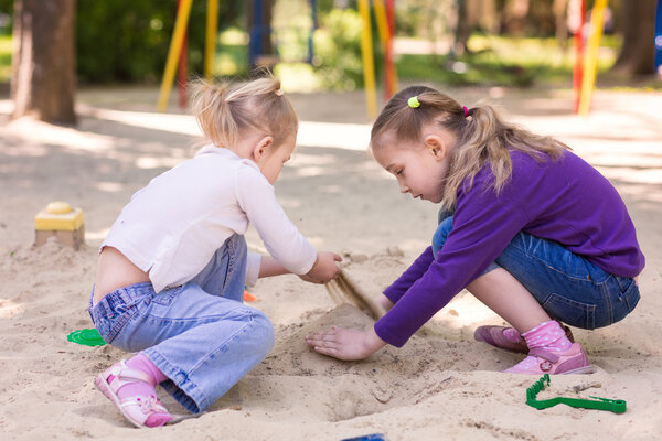 Счастливые маленькие девочки играют в почтовом ящике
