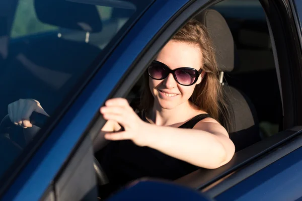 Belle femme d'affaires en lunettes de soleil conduisant dans la voiture — Photo