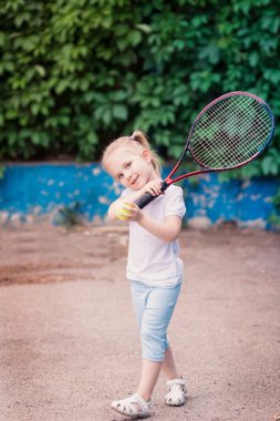 Tenis oynarken sevimli küçük çocuk
