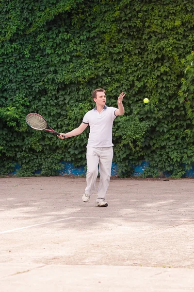 Ekspresyjny młody człowiek, grać w tenisa — Zdjęcie stockowe