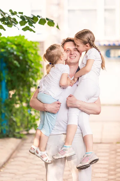 Счастливый молодой отец держит своих детей на улице — стоковое фото