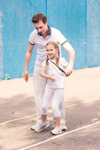 Instructor teaching a child how to play tennis — Stock Photo, Image