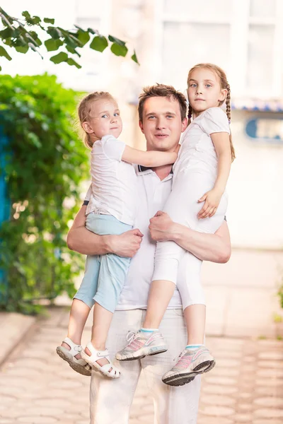 Щасливий молодий батько тримає дітей на відкритому повітрі — стокове фото