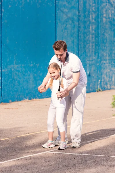 Instructeur enseignant à un enfant comment jouer au tennis — Photo