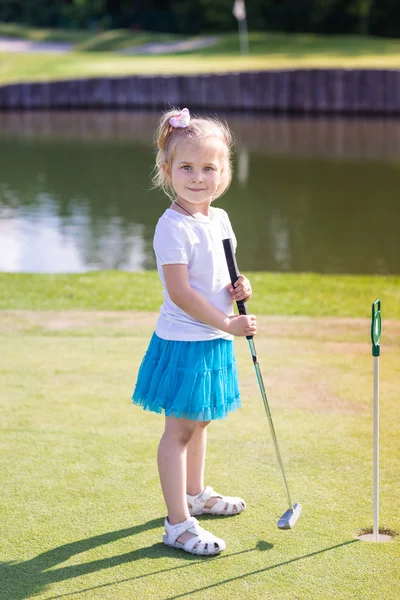 Carino bambina che gioca a golf su un campo — Foto Stock