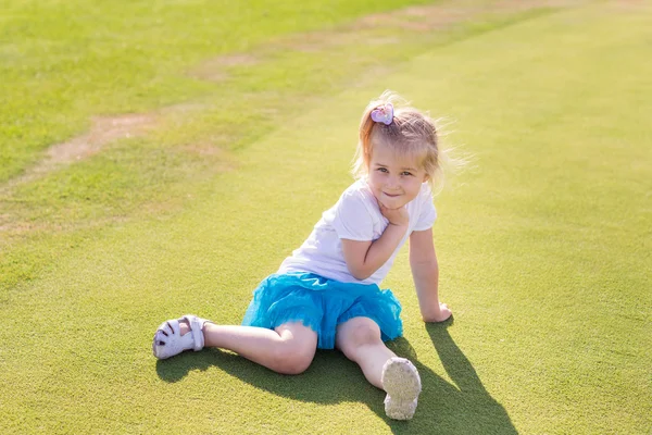 Cute little girl playing golf on a field — Stock Photo, Image