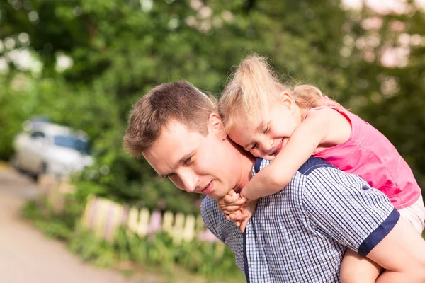 Счастливые отец и дочь играют в парке — стоковое фото