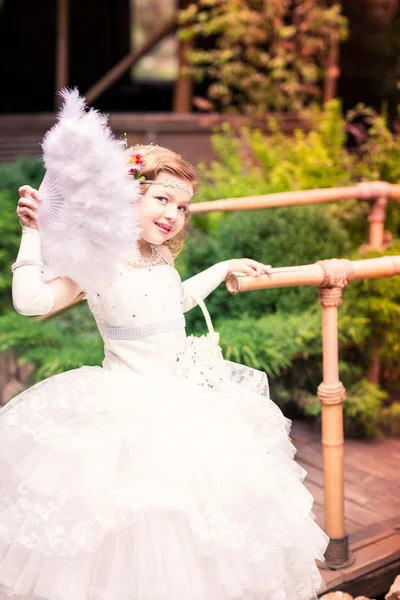 Charmig liten flicka i en vacker klänning utomhus — Stockfoto