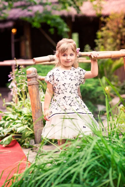 Charmig liten flicka i en vacker klänning utomhus — Stockfoto