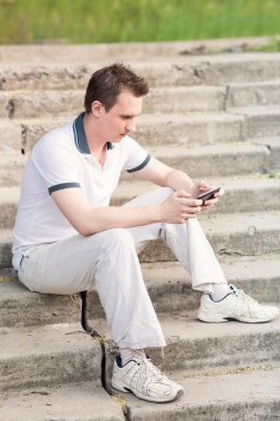 tablet pc ile merdivenlerde oturan genç adam