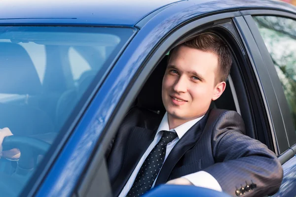 Guapo joven hombre de negocios en su nuevo coche — Foto de Stock