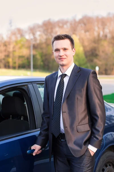 Przystojny młody biznesmen, w pobliżu jego nowy samochód — Zdjęcie stockowe
