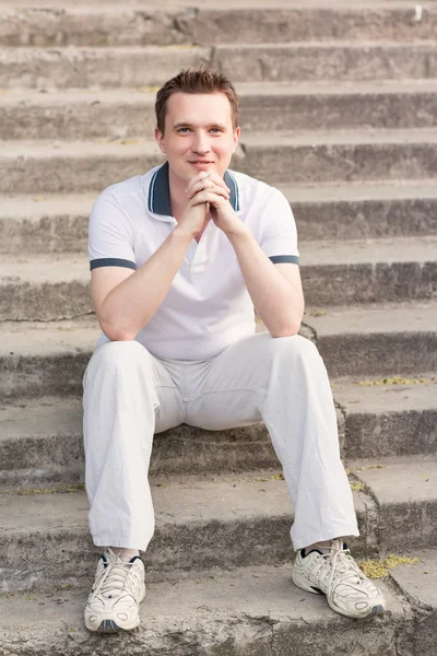 Молодой человек сидит на лестнице — стоковое фото