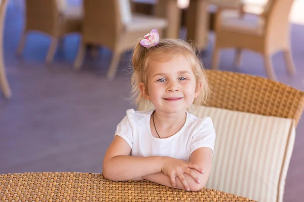 Søtt lite barn ved bordet i en restaurant. – stockfoto