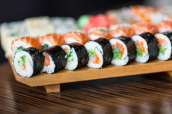 Rollos de sushi servidos en un plato de madera — Foto de Stock