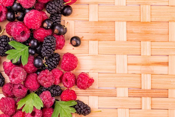 Verse bessen op een rieten achtergrondkleur — Stockfoto