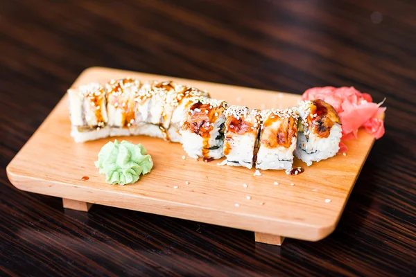 Rollos de sushi servidos en un plato de madera — Foto de Stock