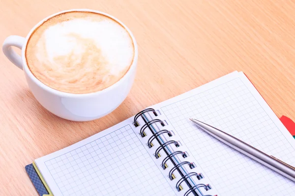 Open blank note book with coffee cup on table