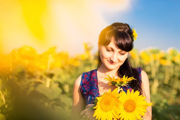 Jonge mooie vrouw in zonnebloem veld — Stockfoto