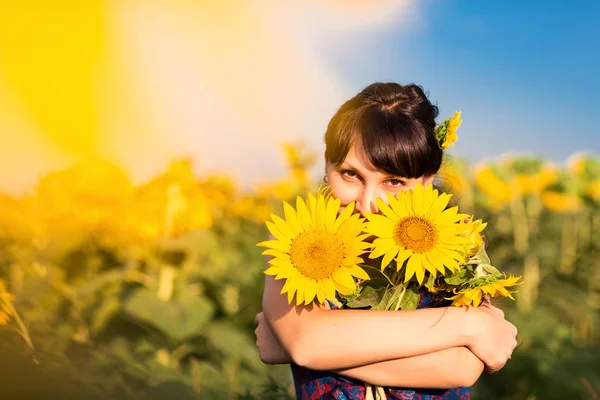 Wanita cantik muda di bidang bunga matahari — Stok Foto