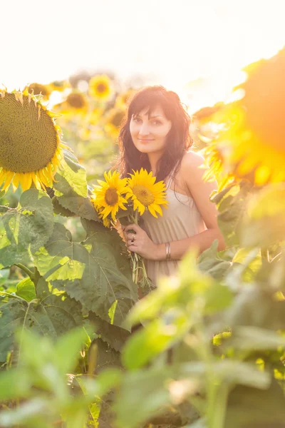 Wanita cantik muda di bidang bunga matahari — Stok Foto