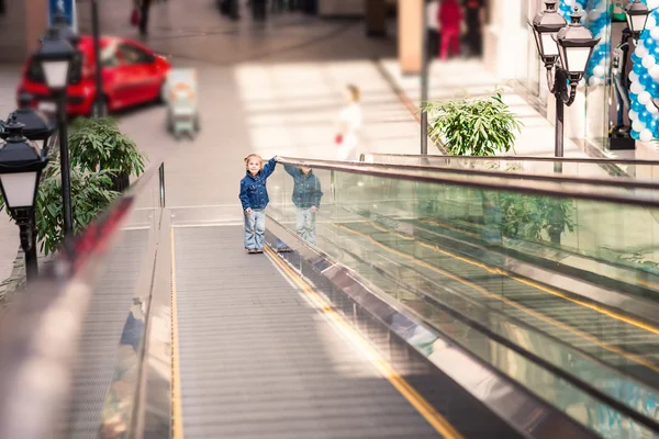 Lindo niño pequeño en el centro comercial en escaleras mecánicas — Foto de Stock