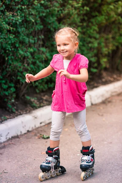 Liten flicka på rullskridskor på park — Stockfoto