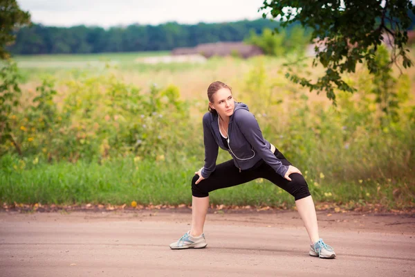 屋外の自然の中でストレッチ ランナー女性 — ストック写真