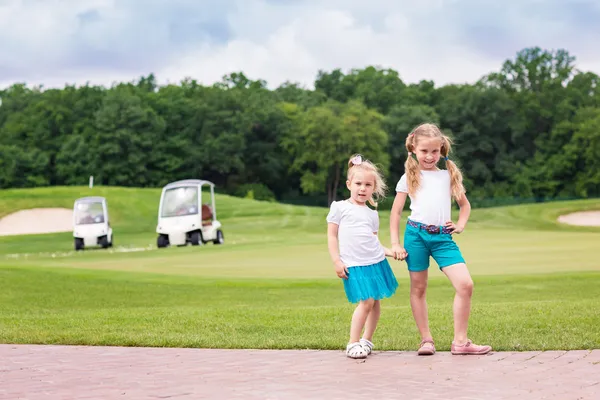 Schattige kleine gilrs op de golfbaan — Stockfoto