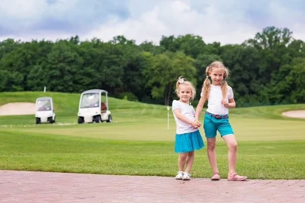 Schattige kleine gilrs op de golfbaan — Stockfoto