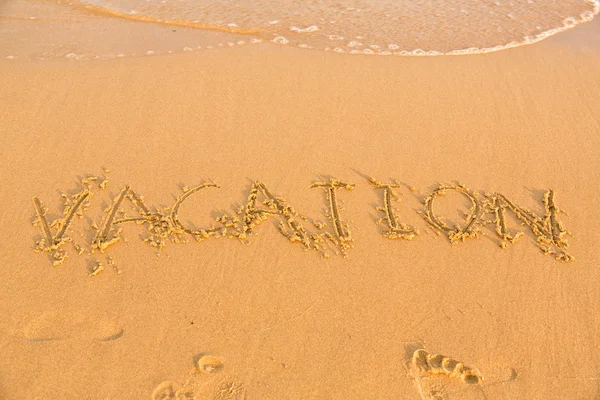 Word vacation on the yellow sandy beach — Stock Photo, Image