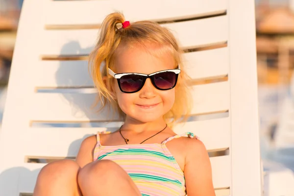 Criança adorável banhos de sol em uma praia — Fotografia de Stock