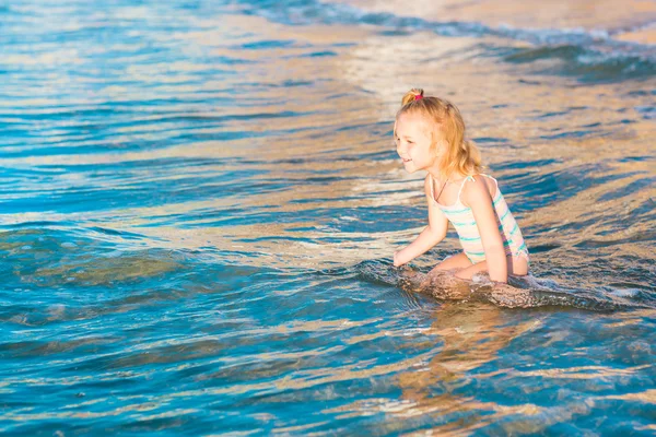Bir plajda denize oynarken sevimli küçük kız — Stok fotoğraf
