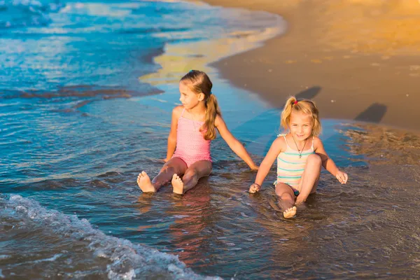 Zwei entzückende Kinder, die im Meer am Strand spielen — Stockfoto