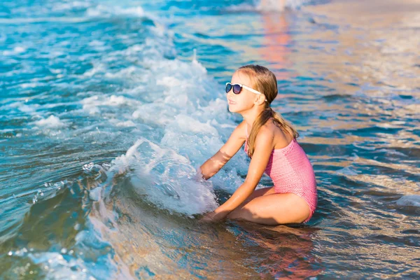 Adorable niña jugando en el mar en una playa —  Fotos de Stock