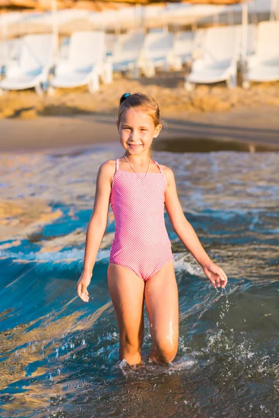 Bir plajda denize oynarken sevimli küçük kız — Stok fotoğraf