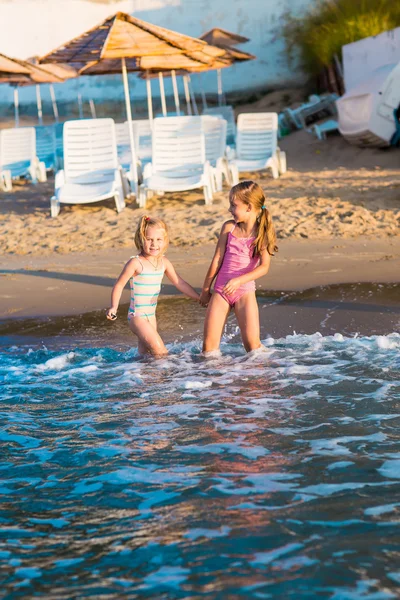 Bir plajda denize oynayan iki sevimli çocuklar — Stok fotoğraf