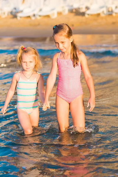 Due adorabili bambini che giocano in mare su una spiaggia — Foto Stock