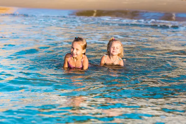 Due adorabili bambini che giocano in mare su una spiaggia — Foto Stock